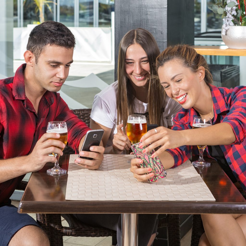 Friends sitting in a bar drinking beer