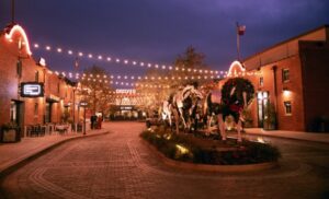 View of the Fort Worth Stock yards featuring historic buildings and the bustling atmosphere of the old Western district with people walking around.