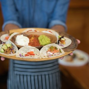 Waiter holding plate of mexican food in bar